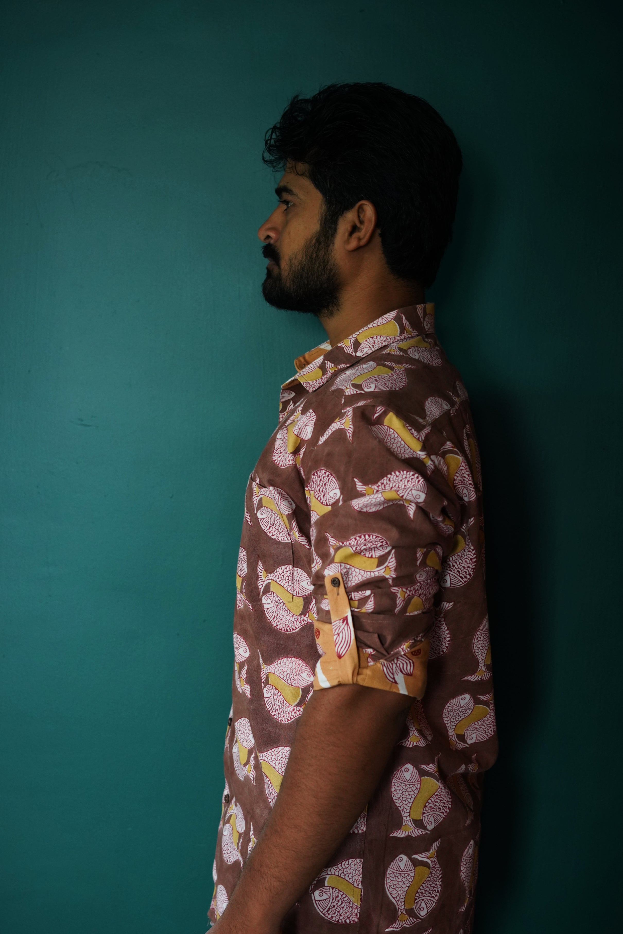 Men's full sleeve cotton shirt featuring fish and sun motif hand block printed using natural dyes in the shades of brown, yellow and red.