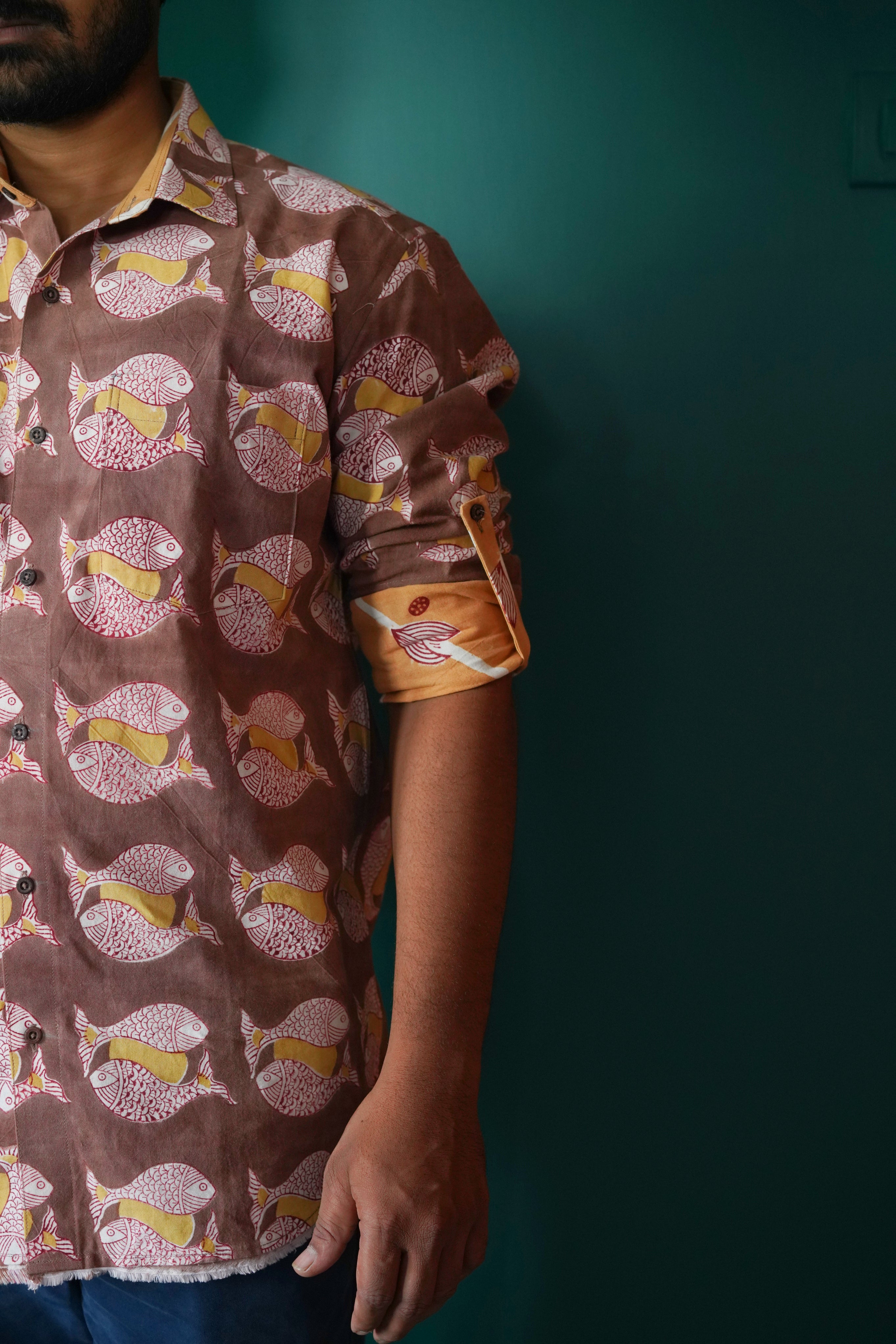 Men's full sleeve cotton shirt featuring fish and sun motif hand block printed using natural dyes in the shades of brown, yellow and red.