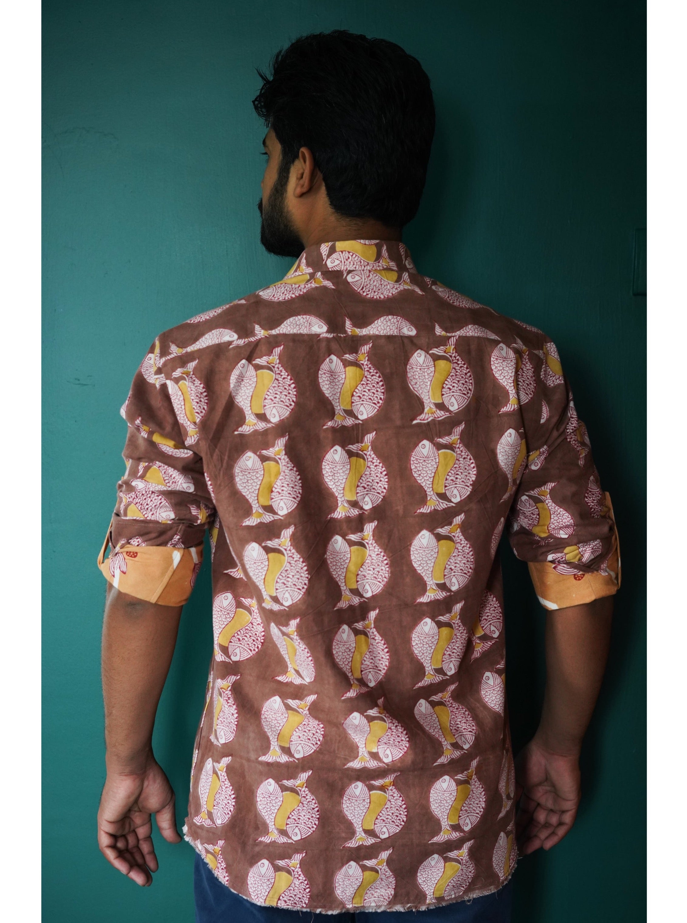 Men's full sleeve cotton shirt featuring fish and sun motif hand block printed using natural dyes in the shades of brown, yellow and red.