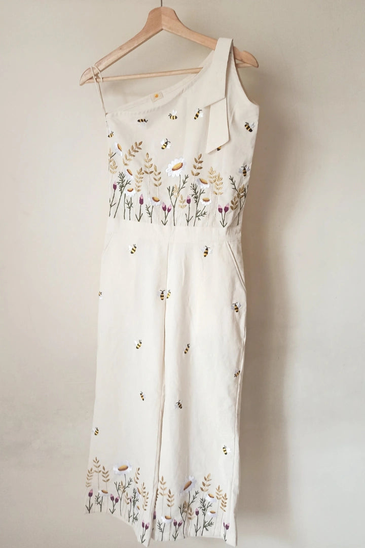 Ilamra sustainable clothing organic cotton Off-white hand block printed jumpsuit which comes with slightly flared pants with side hip slant pockets, side zip closure and hand-embroidered lush flower beds and honey bees. Cool and convenient to wear