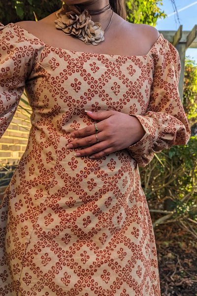 Ilamra hand block printed Kalamkari art organic cotton naturally dyed in Madder red against a beige background, big sleeves, elegant, classy, chic dress