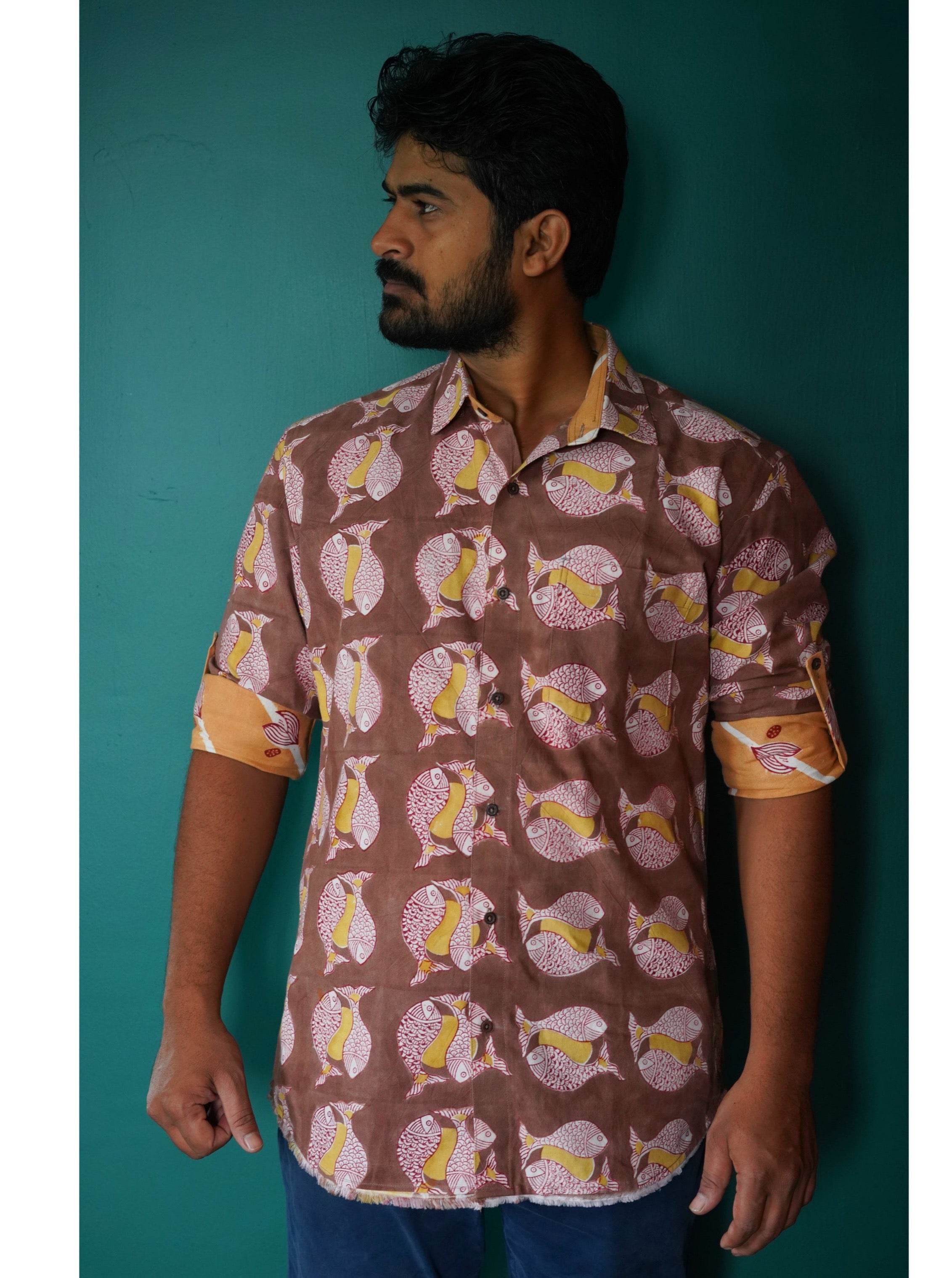 Men's full sleeve cotton shirt featuring fish and sun motif hand block printed using natural dyes in the shades of brown, yellow and red. 